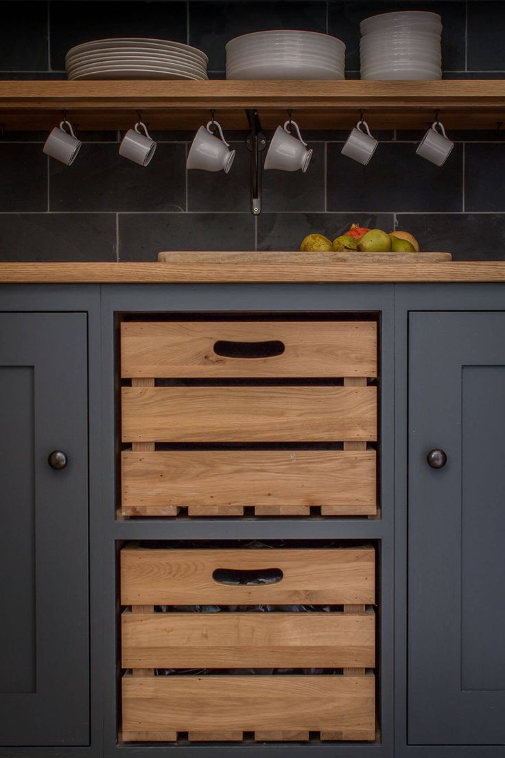 a kitchen with blue cabinets and wooden drawers