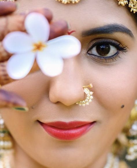 a close up of a woman with flowers in her eyes and nose piercings on