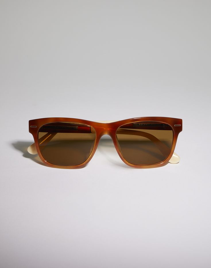 Sartorial Sunset acetate sunglasses Essential lines and color combinations define the contemporary graphic style of these acetate sunglasses. Sophisticated manufacturing techniques enhance the exclusive nuances inspired by the timeless colors of the Brunello Cucinelli collections. The frame is part of the "Sartorial Sunset" line, where material and color combinations create unique effects, like the play of light and shadow at sunset. Thanks to skillful handcrafted techniques and sophisticated co Retro Acetate Square Frame Sunglasses, Retro Square Frame Acetate Sunglasses, Classic Summer Sunglasses In Acetate, Retro Acetate Sunglasses With Uv Protection, Trendy Triacetate Sunglasses With Polarized Lenses, Trendy Sunglasses With Polarized Lenses, Beach Acetate Wayfarer Sunglasses, Acetate Wayfarer Sunglasses With Uva Protection, Classic Acetate Cat Eye Sunglasses With Tinted Lenses