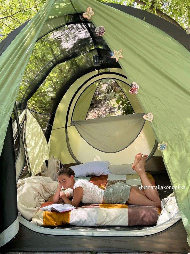 a woman laying on top of a bed in a tent