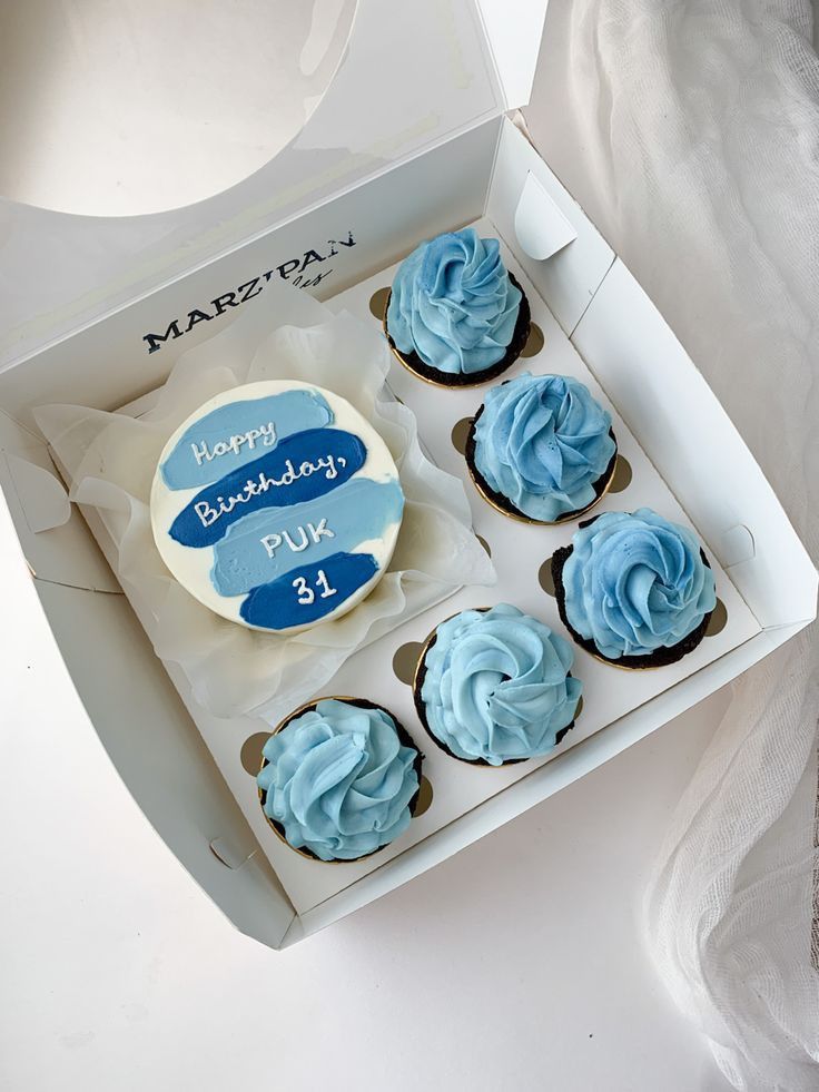 a box of blue cupcakes with frosting