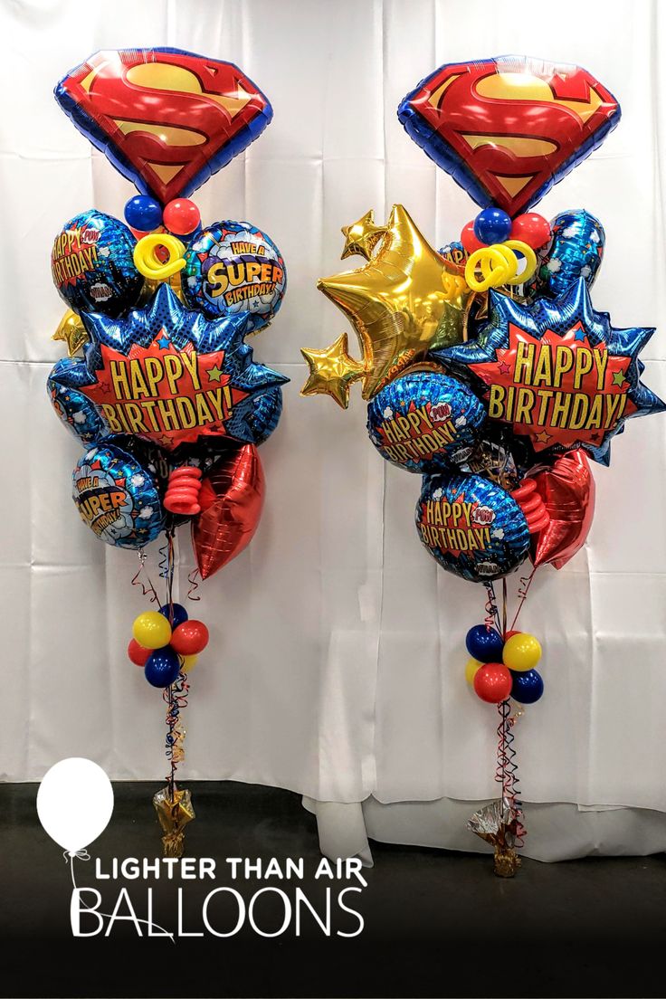 two super hero balloons are hanging on the wall