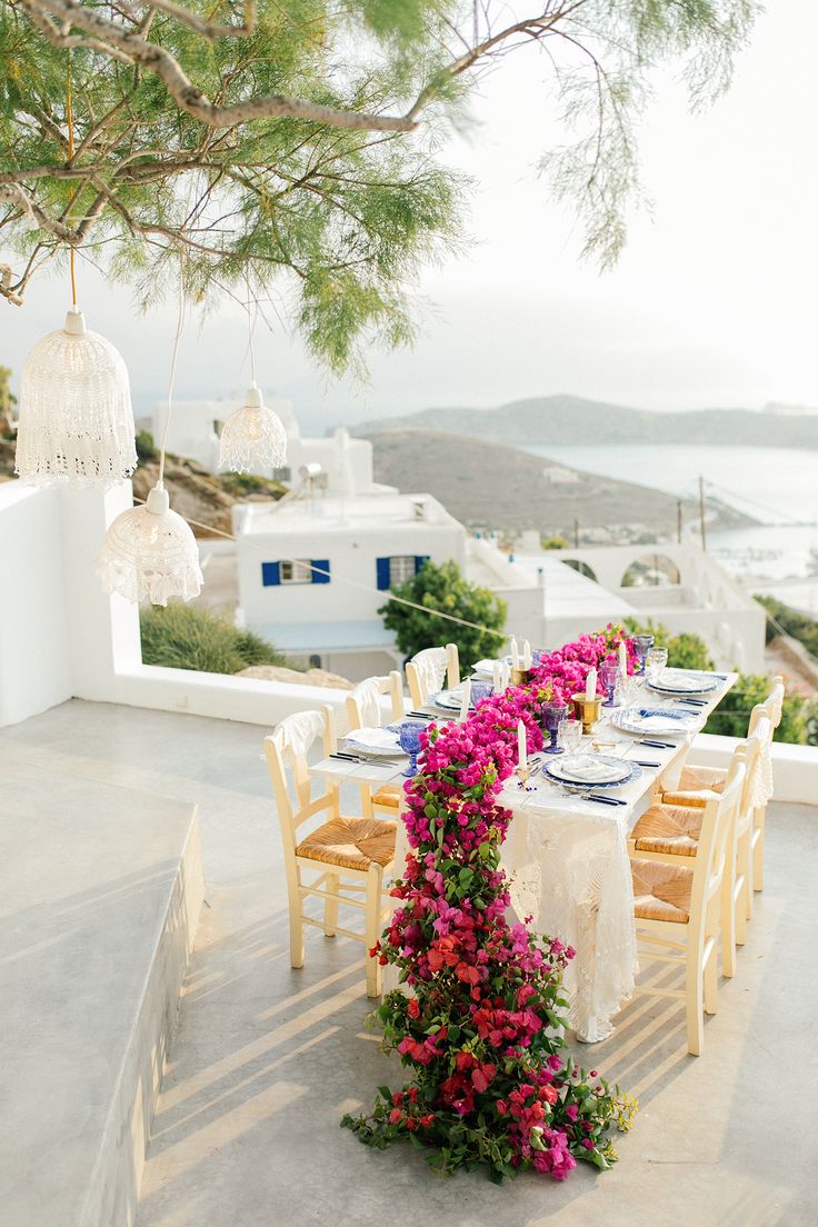 an outdoor dining area with flowers on the table