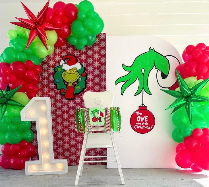 the balloon arch is decorated with green and red balloons, one for dr seuss