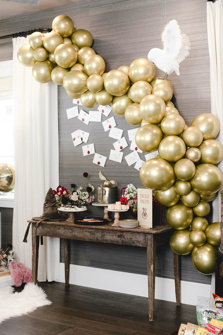 a table topped with lots of gold balloons