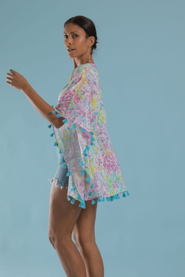 Stylish and easy to wear coverup. A playful flower print with purples and pops of lime on white. Turquoise tassels. Drawstring waist. This elegant and modern caftan works as beachwear, loungewear, or layered over a camisole for a casual look. Tie it open for a kimono style. Multicolor Flowy Cover-up For Beach Party, Breezy Spring Tunic Cover-up, Blue Beach Tops With Tassels, Spring Beach Cover-up Breezy Kaftan, Beach Blue Tops With Tassels, Blue Tassel Tops For Beach, Multicolor Summer Cover-up With Tassels, Beachy Tops For Spring Pool Days, Beachy Tops For Spring Pool Occasions