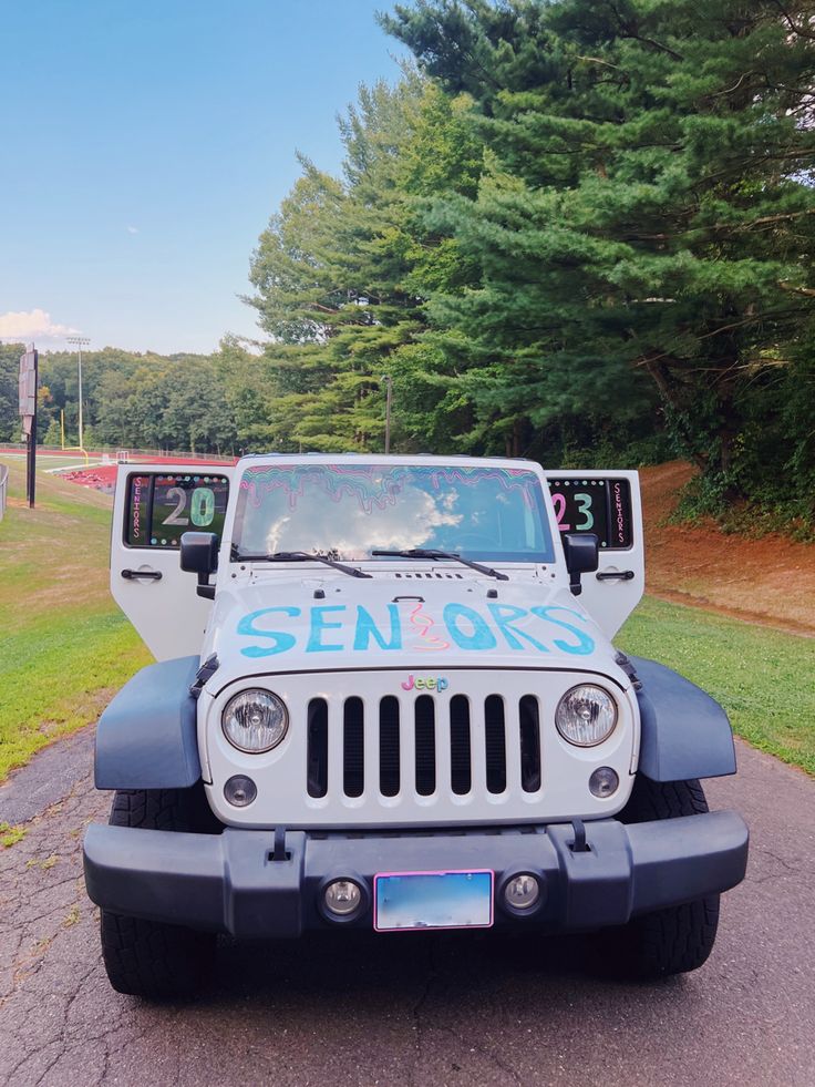 a white jeep parked on the side of a road