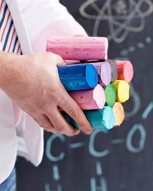 a person holding a bunch of colored chalks in their hands