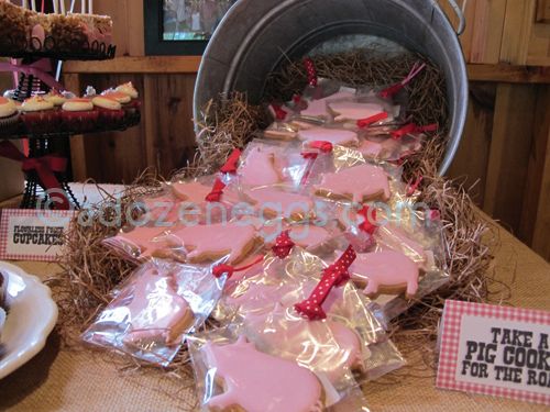 some pink cookies are in the shape of hearts on top of tin cans and straw