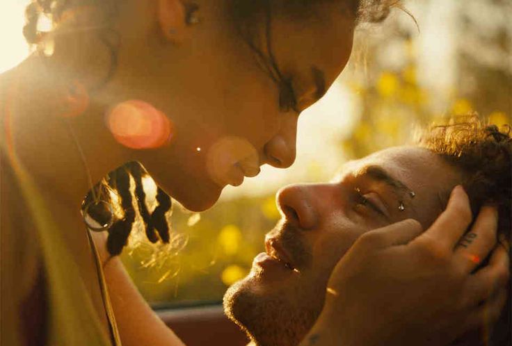 a man getting his hair combed by another mans ear and nose as the sun shines in the background