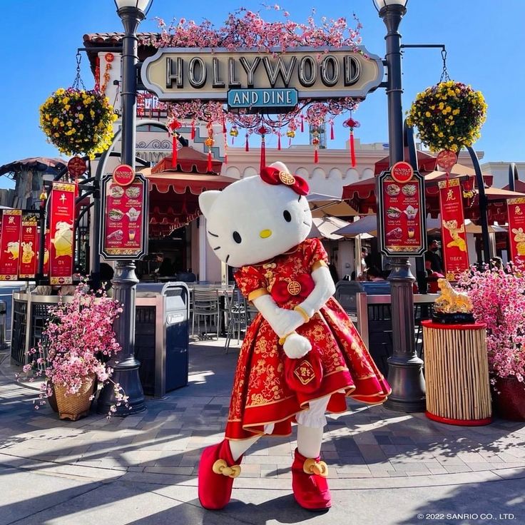 a hello kitty doll is standing in front of the hollywood studios entrance at disneyland world