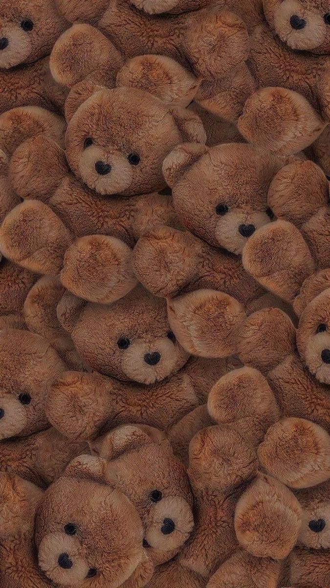 a large group of brown teddy bears sitting next to each other on top of one another