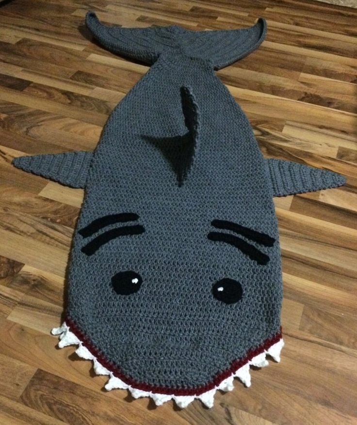 a crocheted shark rug is on the floor with it's mouth open