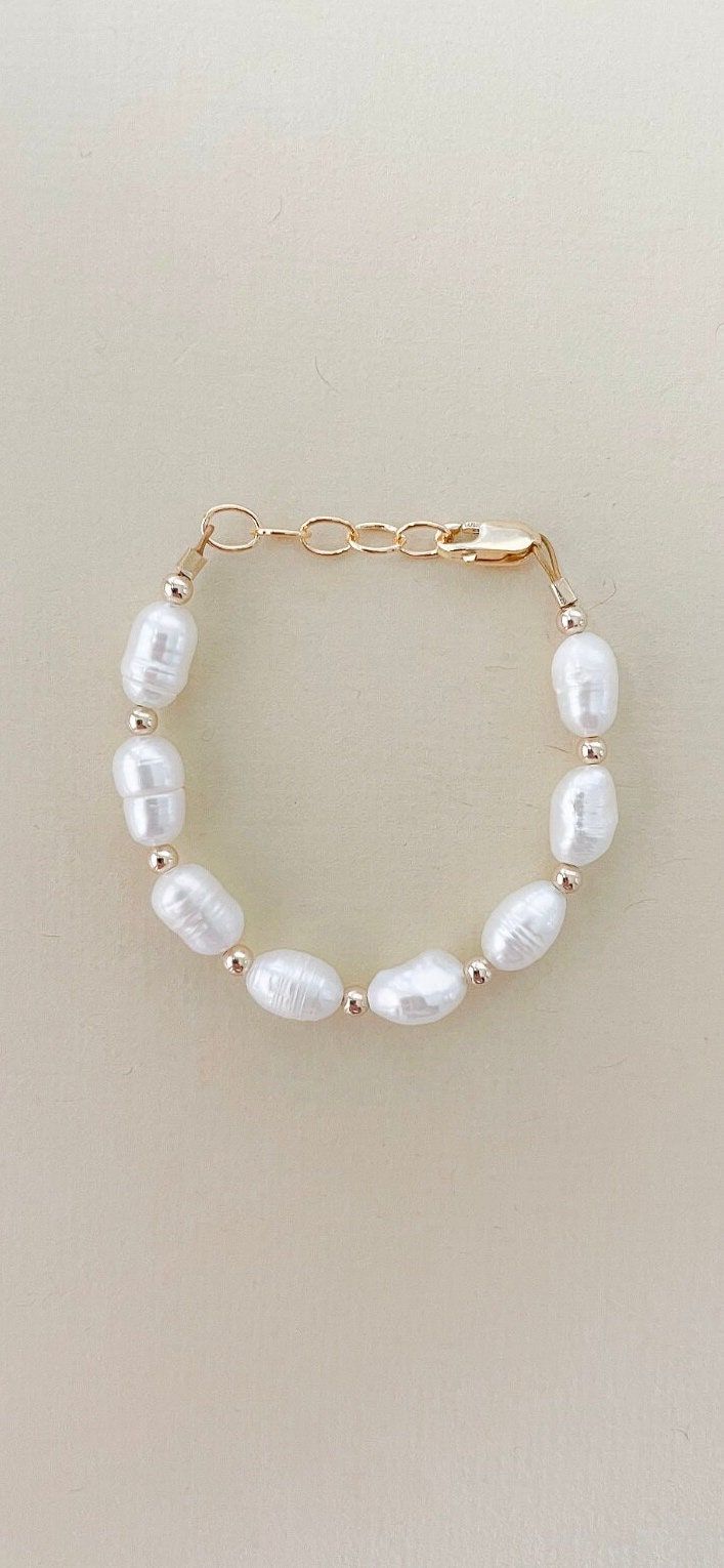 This bracelet is stunning in person! 6mm rice pearls with 14k gold filled bead in between each pearl. This is a perfect keepsake and gift for baby blessings, baptisms, birthdays, Christmas.  Proudly handmade in the USA with materials only made in the USA White Pearl Gold Bracelet With Pearl Drop, White Gold Bracelet With Pearl Drop, White Gold Pearl Bracelet With Pearl Drop, Elegant Pearl Jewelry For Baptism, Gold Pearl Jewelry For Baptism, White Pearl Chain Bracelet In 14k Gold Filled, Classic White Pearl Bracelet With 14k Gold Fill, Hypoallergenic White Pearl Bracelet In 14k Gold Filled, Pearl Bracelet For First Communion