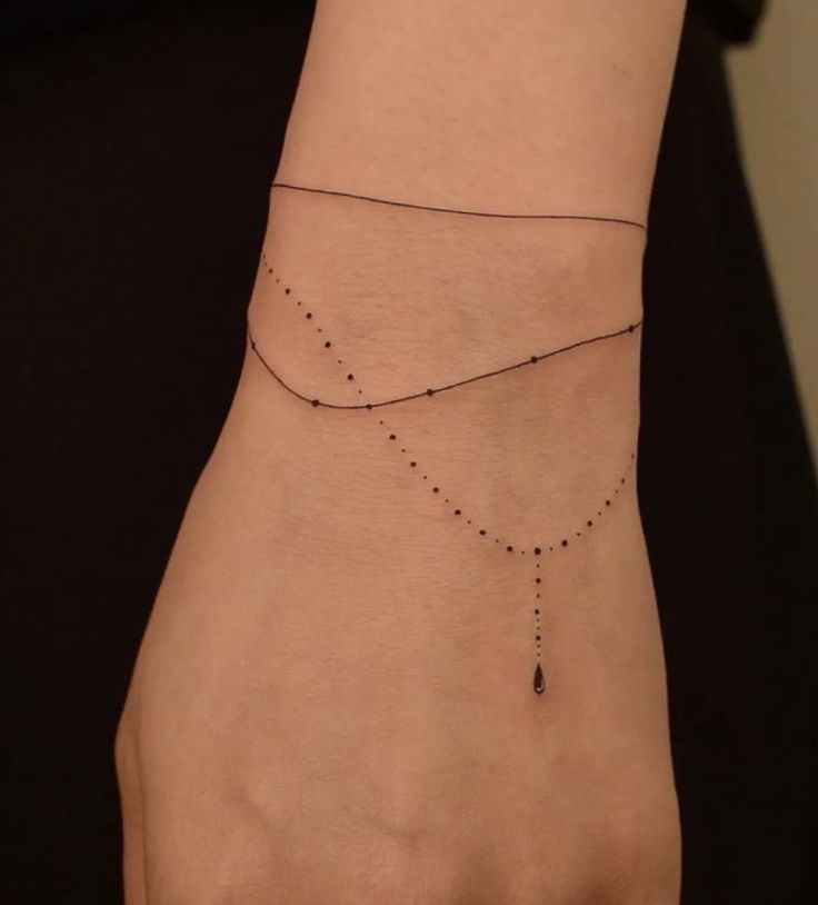 a woman's hand with a small black beaded bracelet on her left wrist