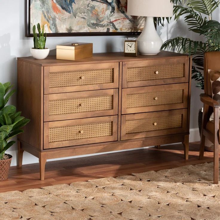 a wooden dresser sitting next to a painting on the wall