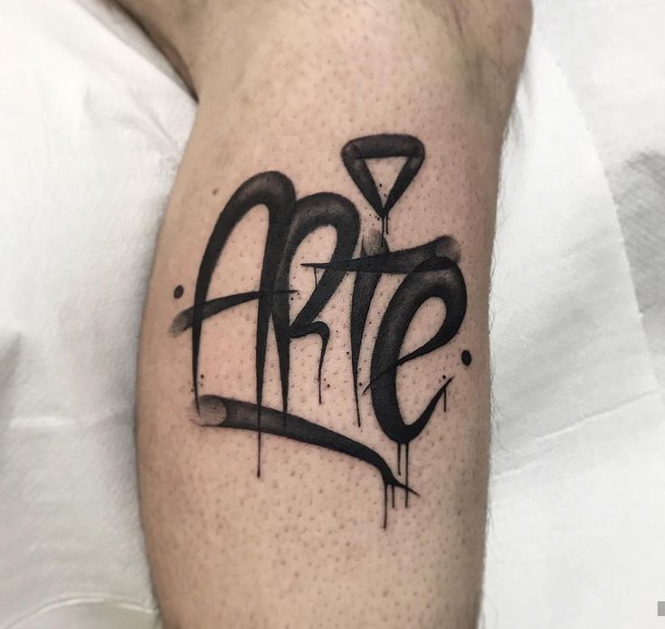 an arm with the word art on it and some black paint splattered over it