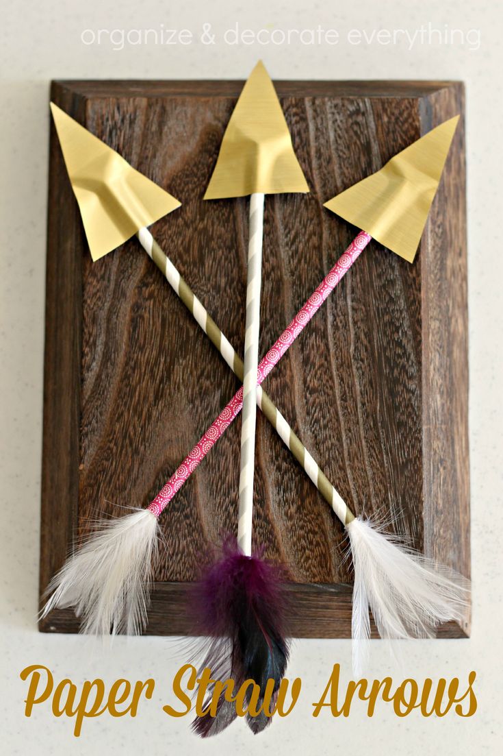 two paper straw arrows with feathers on them