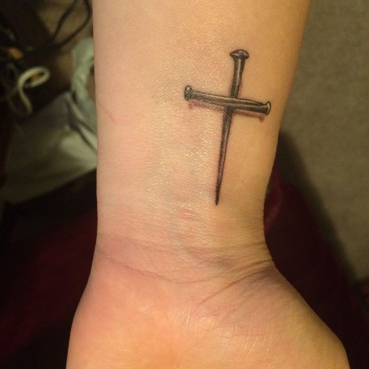 a small cross tattoo on the wrist