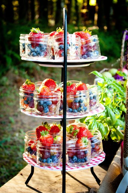 three tiered trays filled with fruit on top of a wooden table