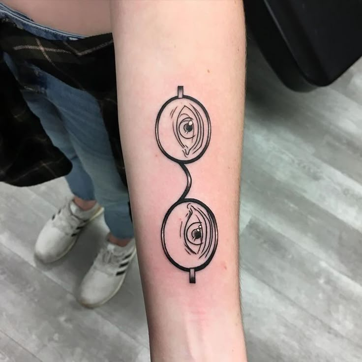 a person with a tattoo on their arm that has an eyeball and spiral design