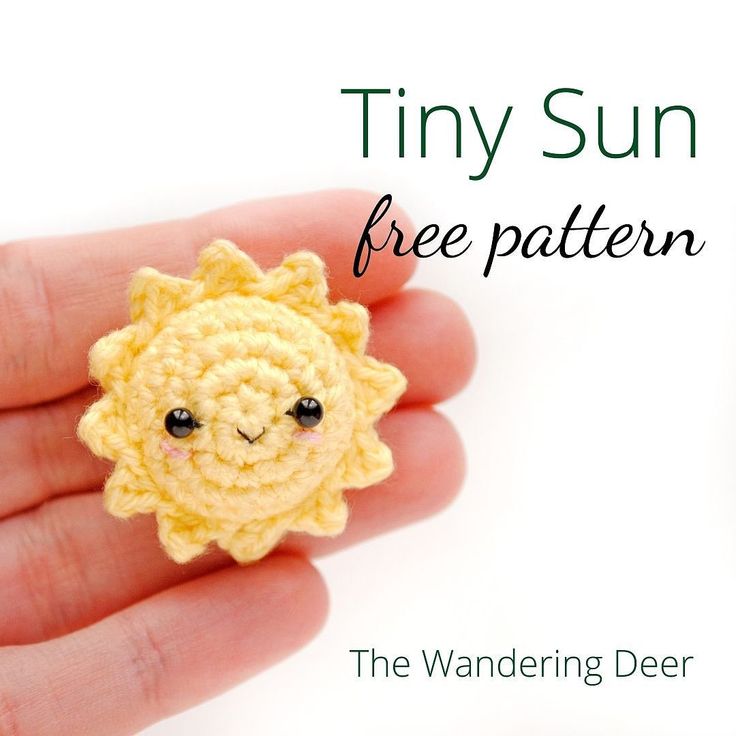 a tiny crochet sunflower is shown in the palm of someone's hand