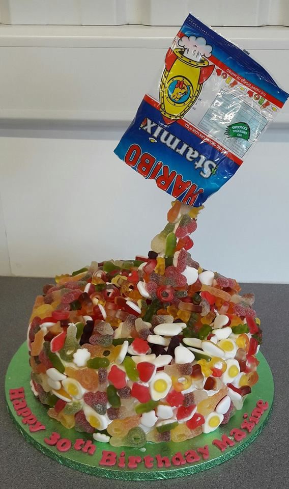 a cake with gummy bears on it and a flag sticking out of the top