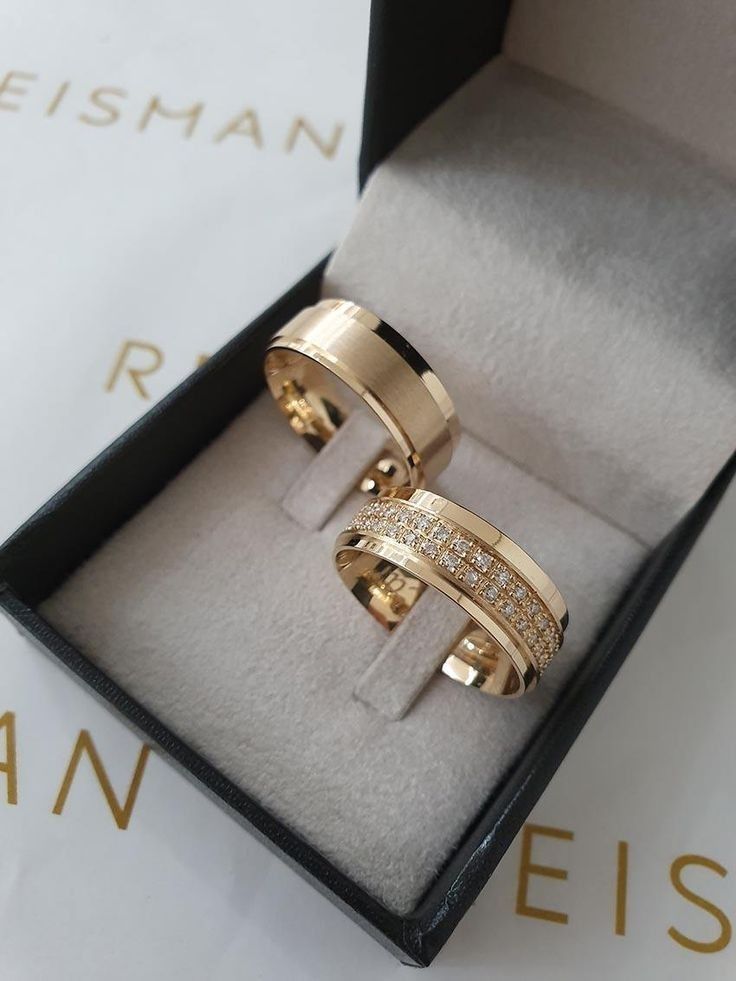 two gold rings with diamonds in a box