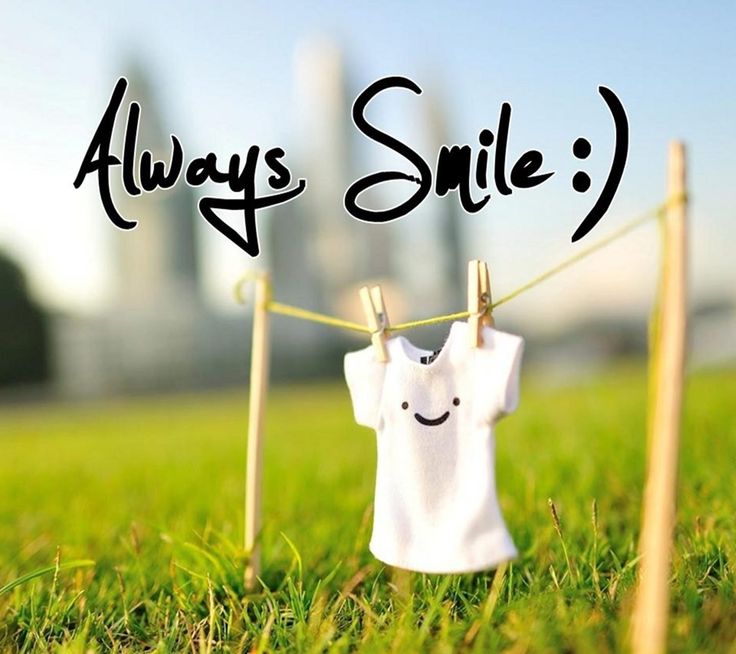 a white shirt hanging on a clothes line with the words always smile written above it