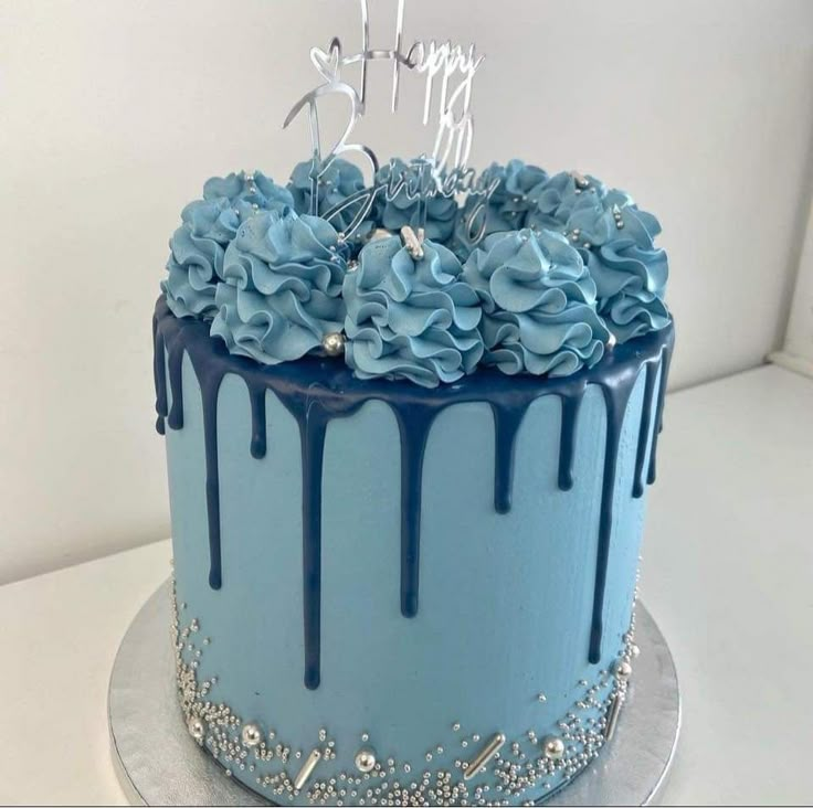 a blue birthday cake with flowers on top