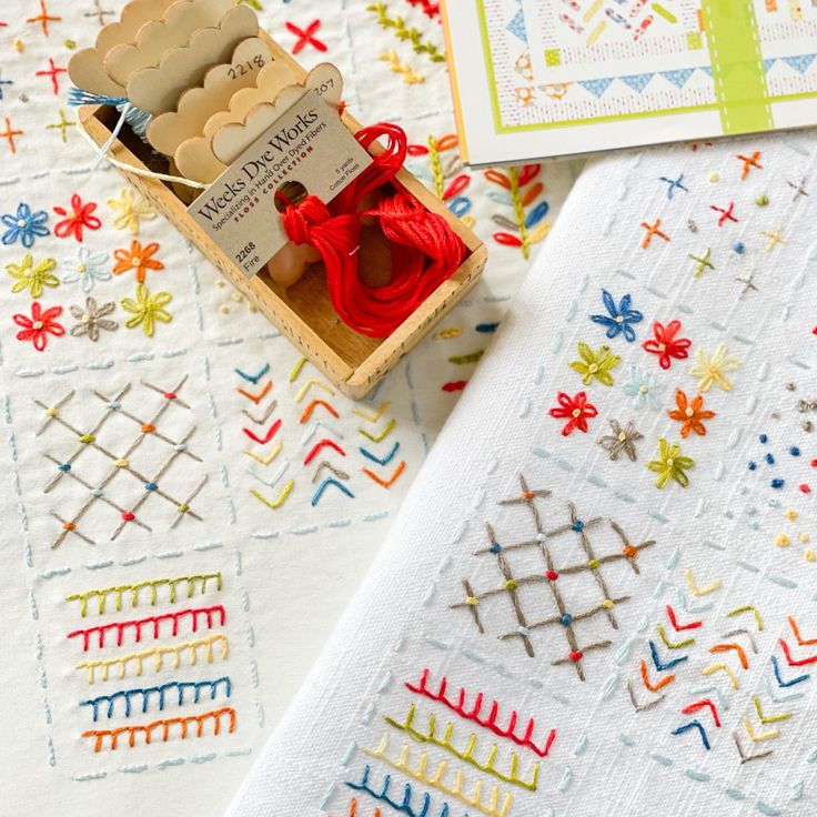 an assortment of handmade items are displayed on a tablecloth with colorful patterns and designs