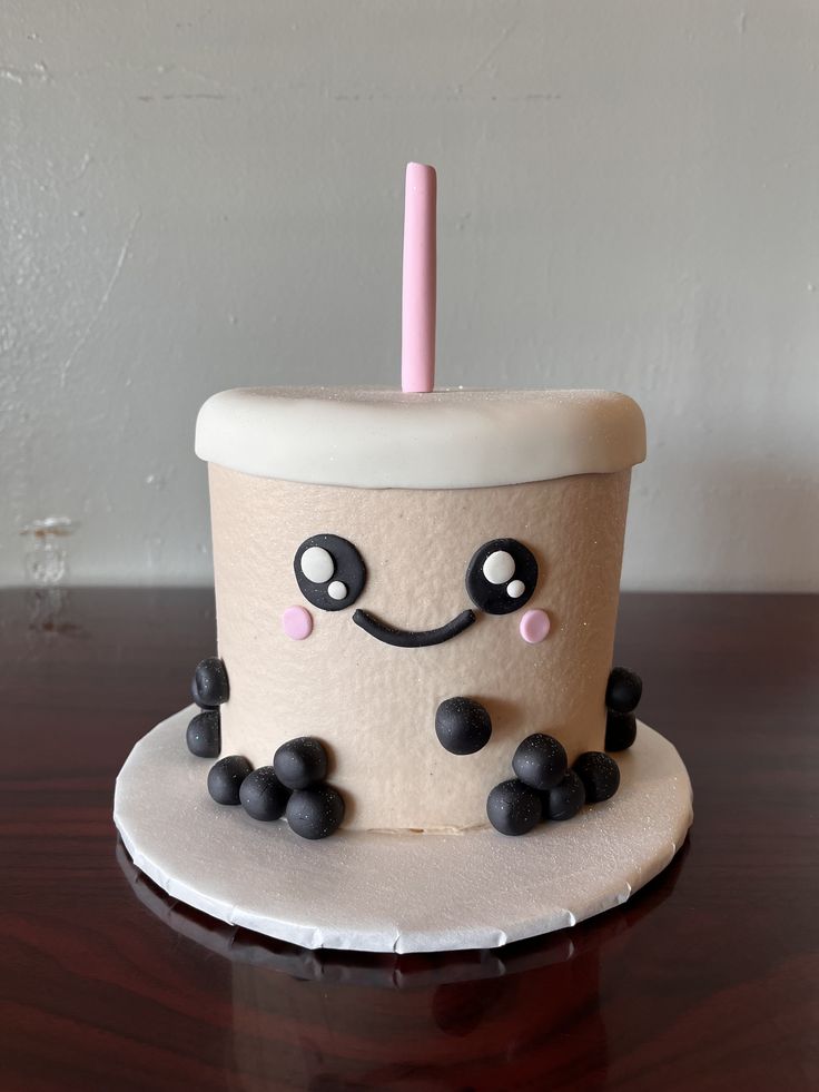 a birthday cake made to look like a coffee cup with a candle sticking out of it