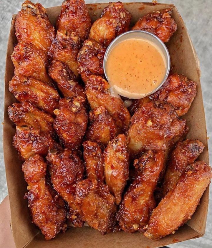 chicken wings with dipping sauce in a cardboard box