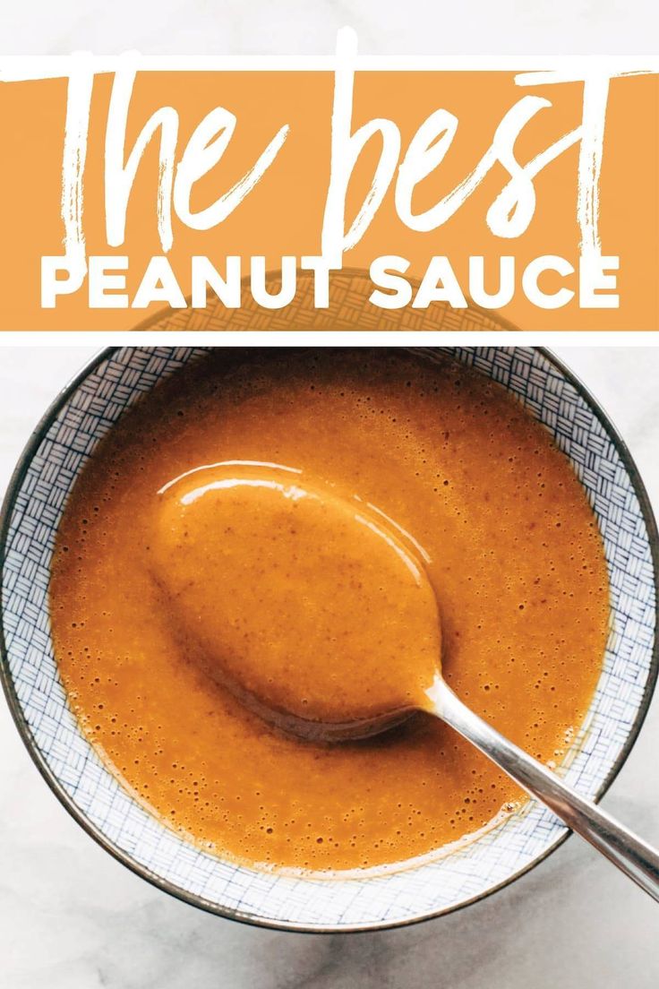 the best peanut sauce is in a bowl with a spoon on it and an orange sign that reads, the best peanut sauce