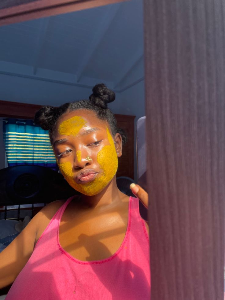 Turmeric face mask on brown skin woman. Mirror picture . Clothing is : pink tank top , nose ring as accessory Intro Pictures, Tumeric Masks, Turmeric Mask, Face Mask Aesthetic, Summer Vision, Natural Mask, Turmeric Face Mask, Mask Aesthetic, Tumeric Face Mask