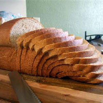 a loaf of bread sitting on top of a wooden cutting board next to a knife