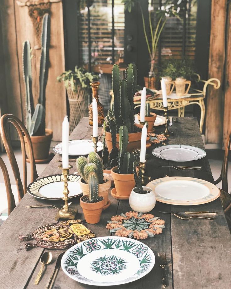 a wooden table topped with lots of plates and potted plants next to each other