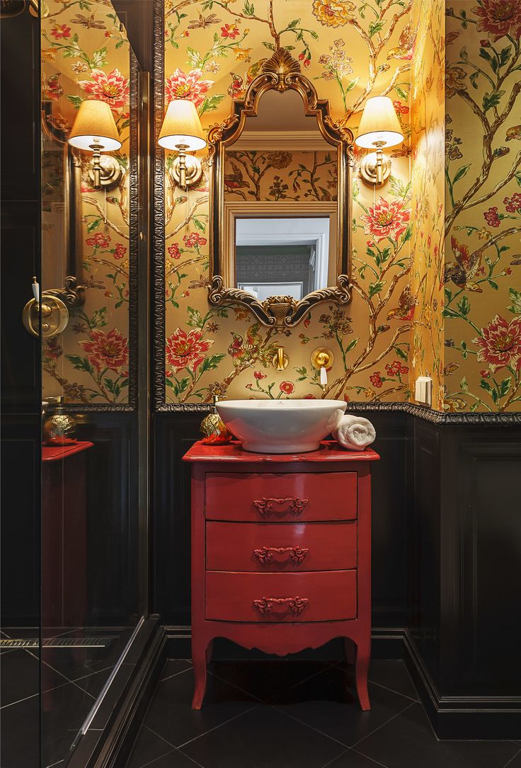 a bathroom with a sink, mirror and red cabinet in the corner next to it