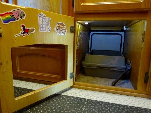 an open wooden toy refrigerator with stickers on it's doors and door handle