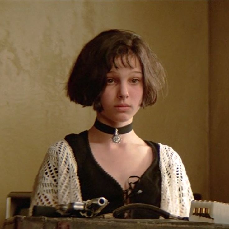 a woman wearing a choker sitting at a table