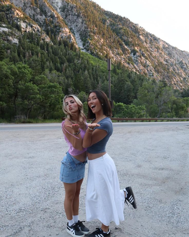 two women standing next to each other in the dirt