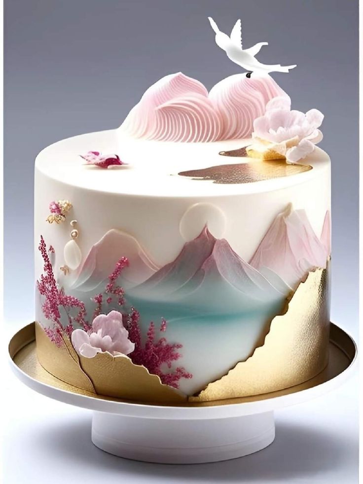 a white cake with pink flowers on it and a bird flying over the top of it