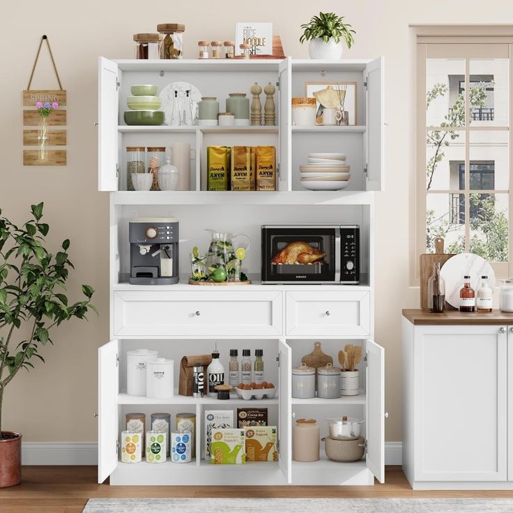 a kitchen with white cabinets and shelves filled with food