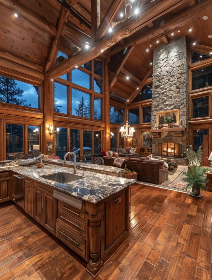 a large kitchen and living room in a house with wood flooring on the walls