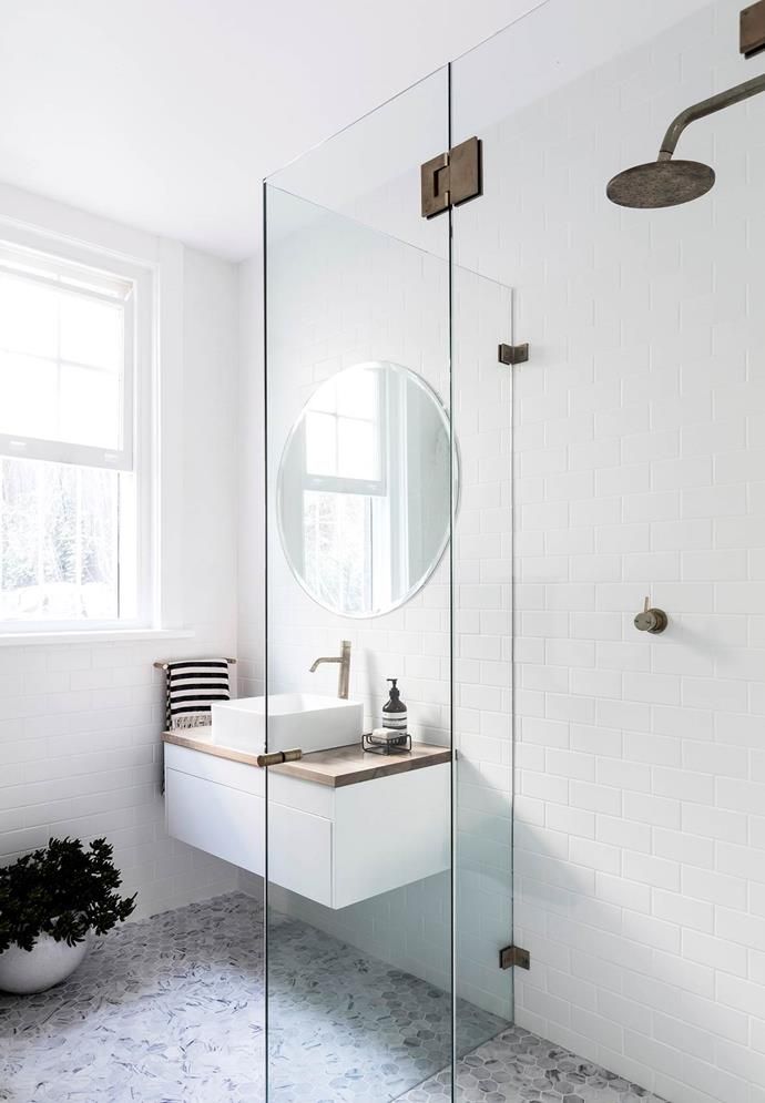 a bathroom with a sink, mirror and shower stall in the middle of the room