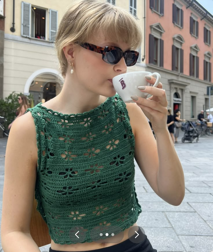 a woman wearing sunglasses drinking from a cup