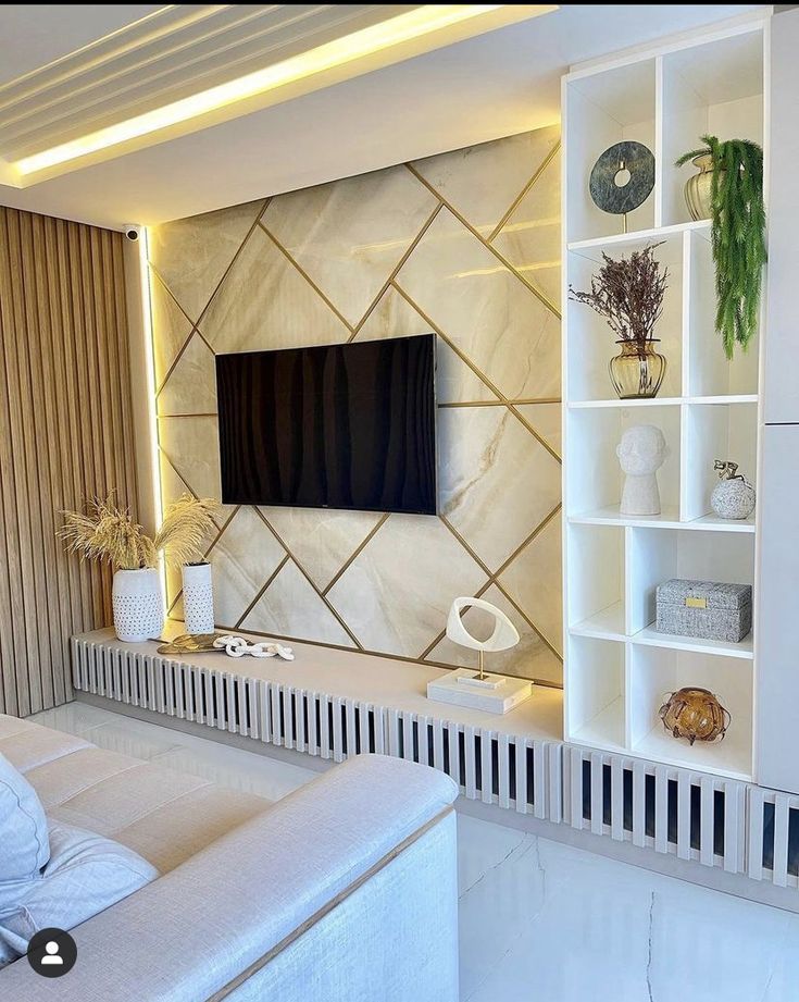 a living room with white furniture and a flat screen tv mounted on the wall above it