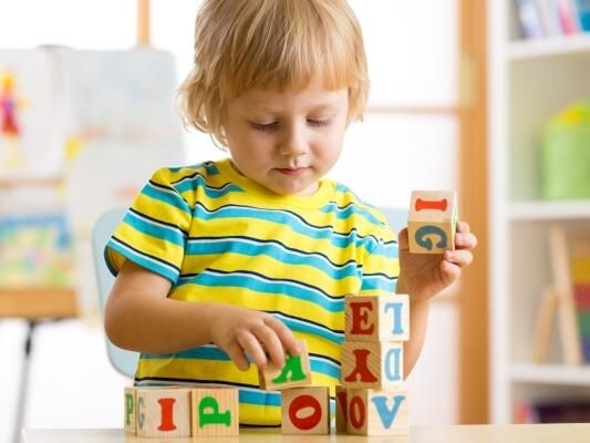 a little boy playing with wooden blocks at a table