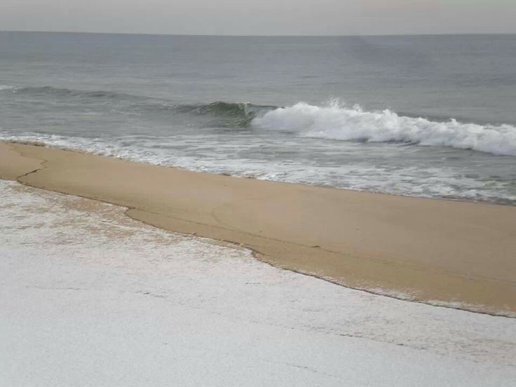 an empty beach with waves coming in from the ocean