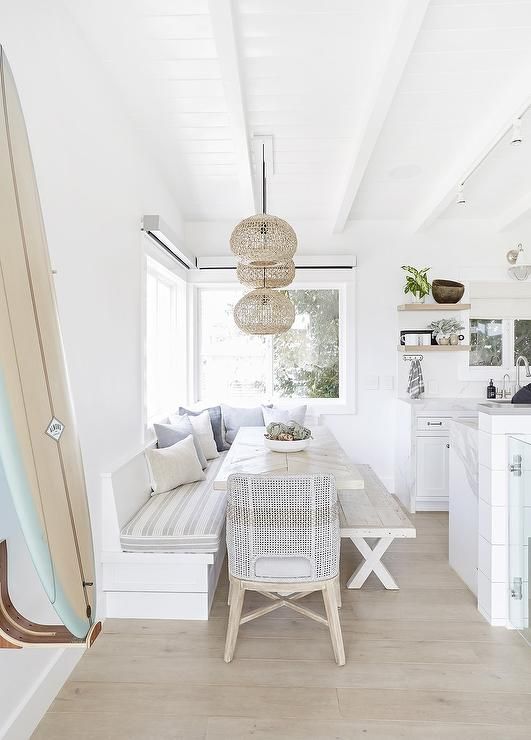 a white kitchen and dining room with wood flooring